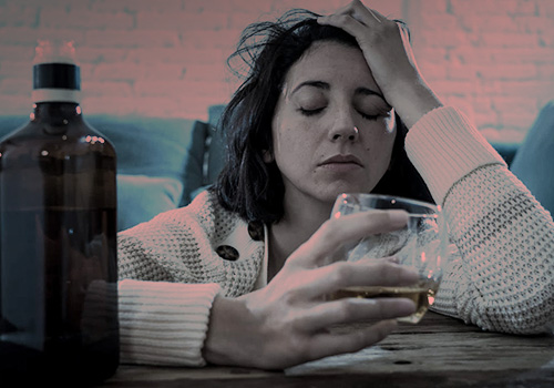 Женщина в депрессии с бокалом спиртного